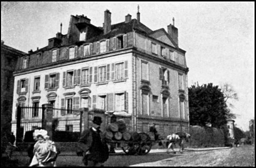 A large house surrounded by railings, and the street in front showing a horse and cart